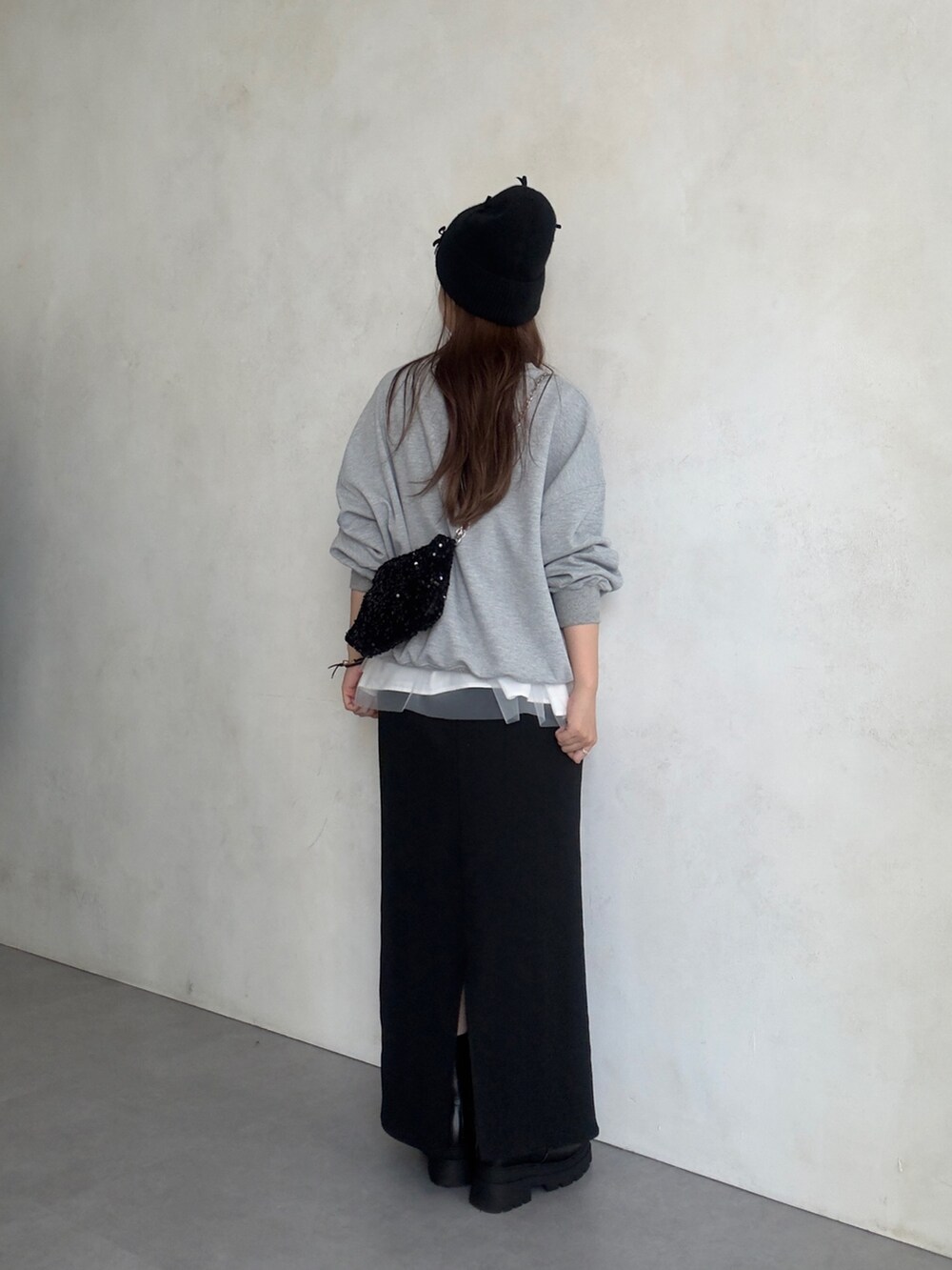 ホワイト系のキャミソール、ブラック系のスカート、ブラック系のブーツを着用したレディースの夏コーディネートの3枚目の写真