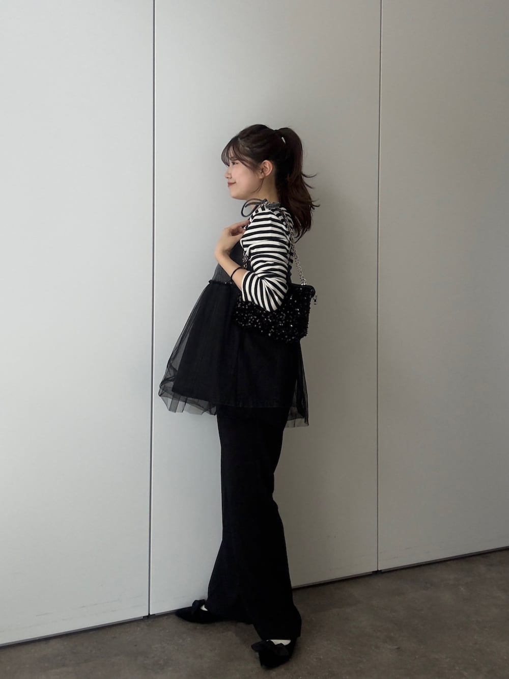 ブラック系のTシャツ/カットソー、ブラック系のショルダーバッグ、ブラック系のキャミソールを着用したレディースの春コーディネートの2枚目の写真