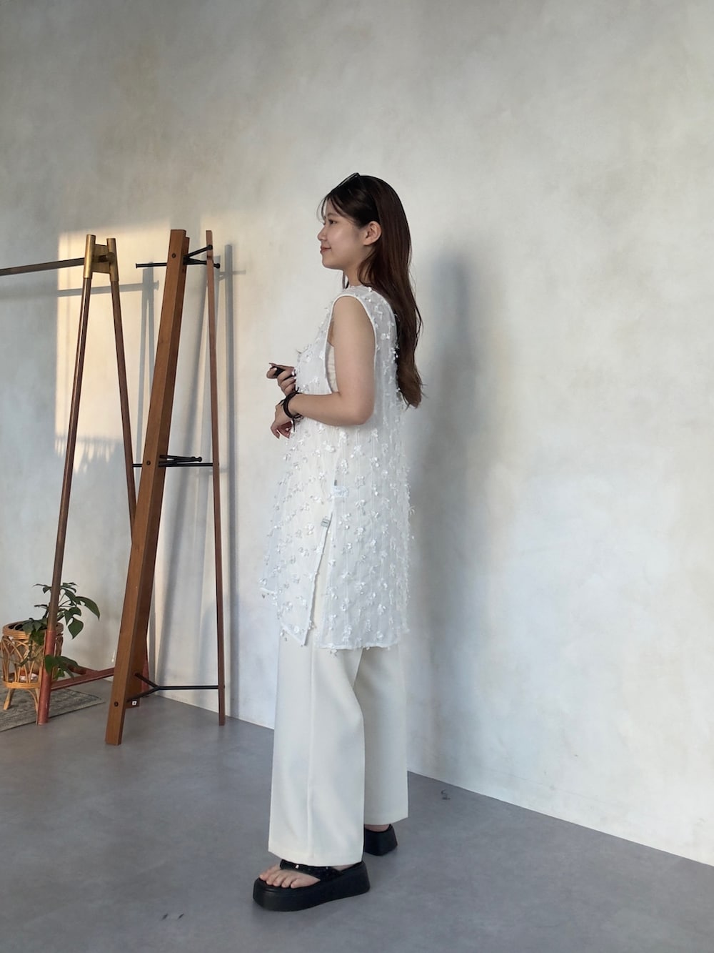 ホワイト系のその他パンツ、ブラック系のかごバッグ、ブラック系のサンダルを着用したレディースの夏コーディネートの2枚目の写真