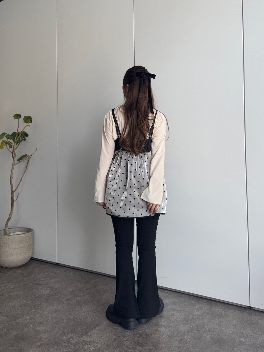 ブラック系のショルダーバッグ、ブラック系のその他パンツ、ホワイト系のTシャツ/カットソーを着用したレディースの冬コーディネートの3枚目の写真