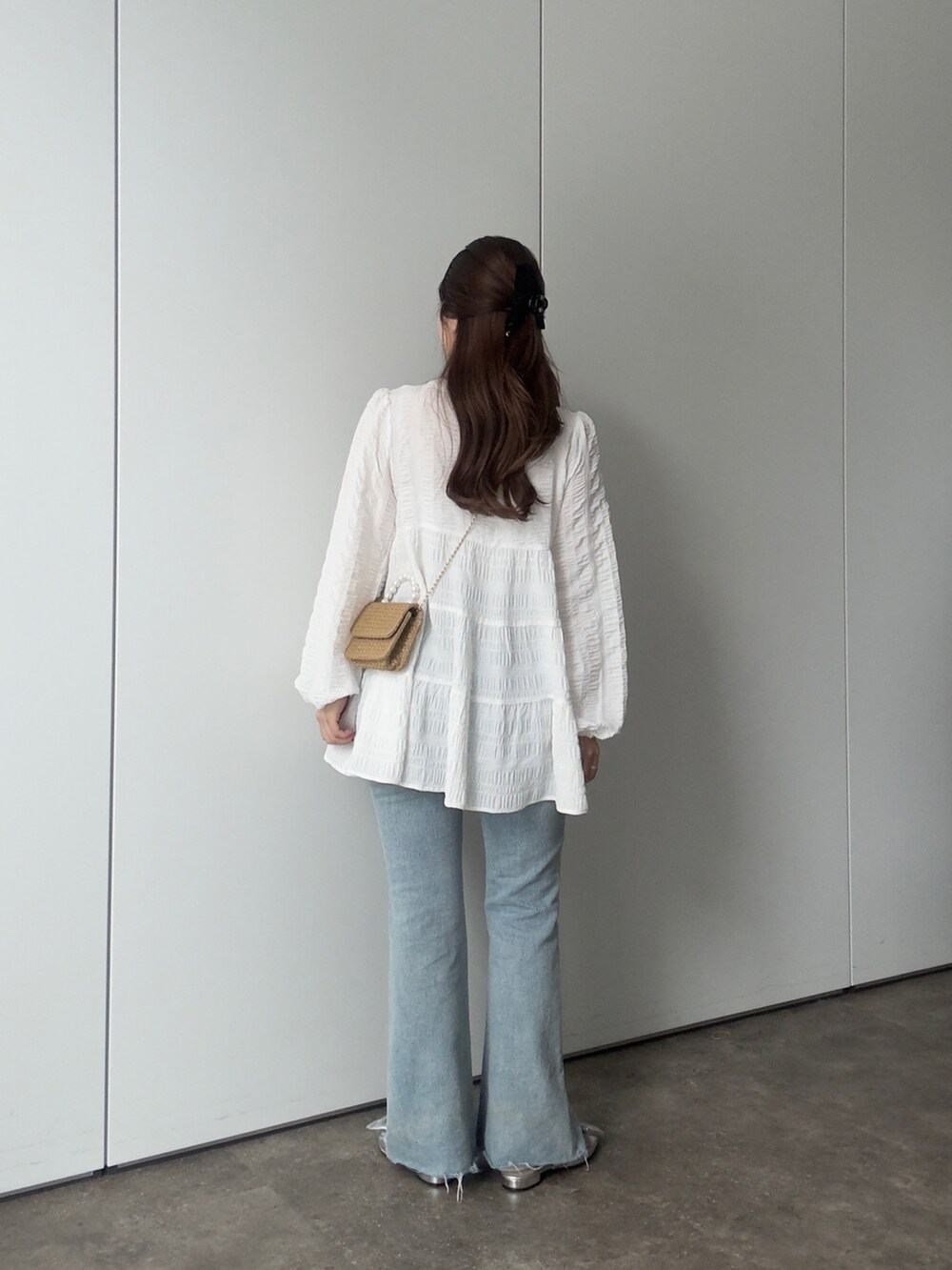 ホワイト系のシャツ/ブラウス、ブルー系のデニムパンツ、シルバー系のパンプスを着用したレディースの春コーディネートの3枚目の写真