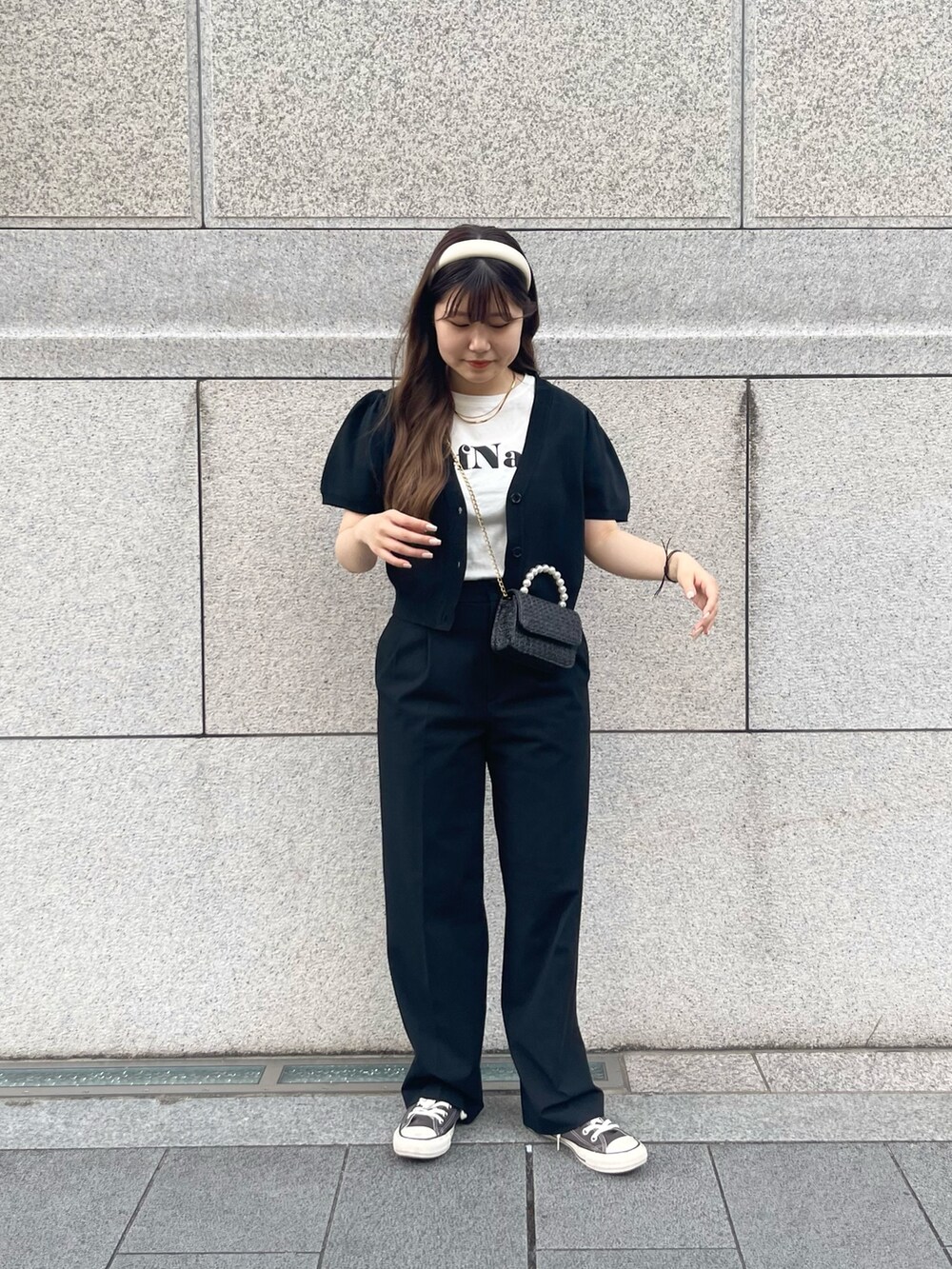 ブラック系のショルダーバッグ、ホワイト系のTシャツ/カットソー、ブラック系のカーディガン/ボレロを着用したレディースの春コーディネートの3枚目の写真