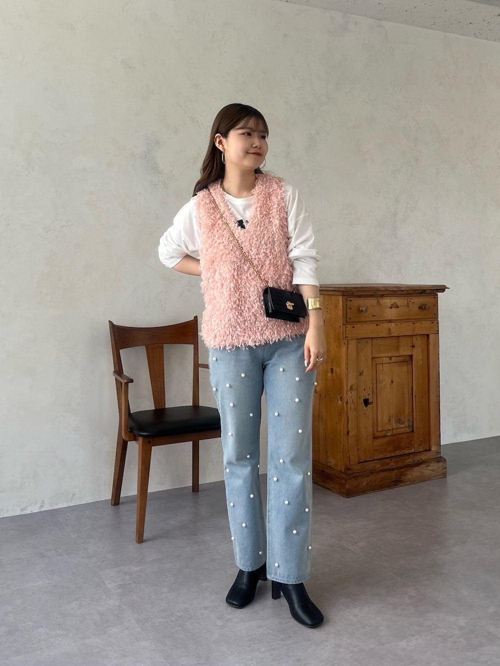 ホワイト系のTシャツ/カットソー、ブルー系のデニムパンツ、ピンク系のベストを着用したレディースの秋コーディネートの2枚目の写真