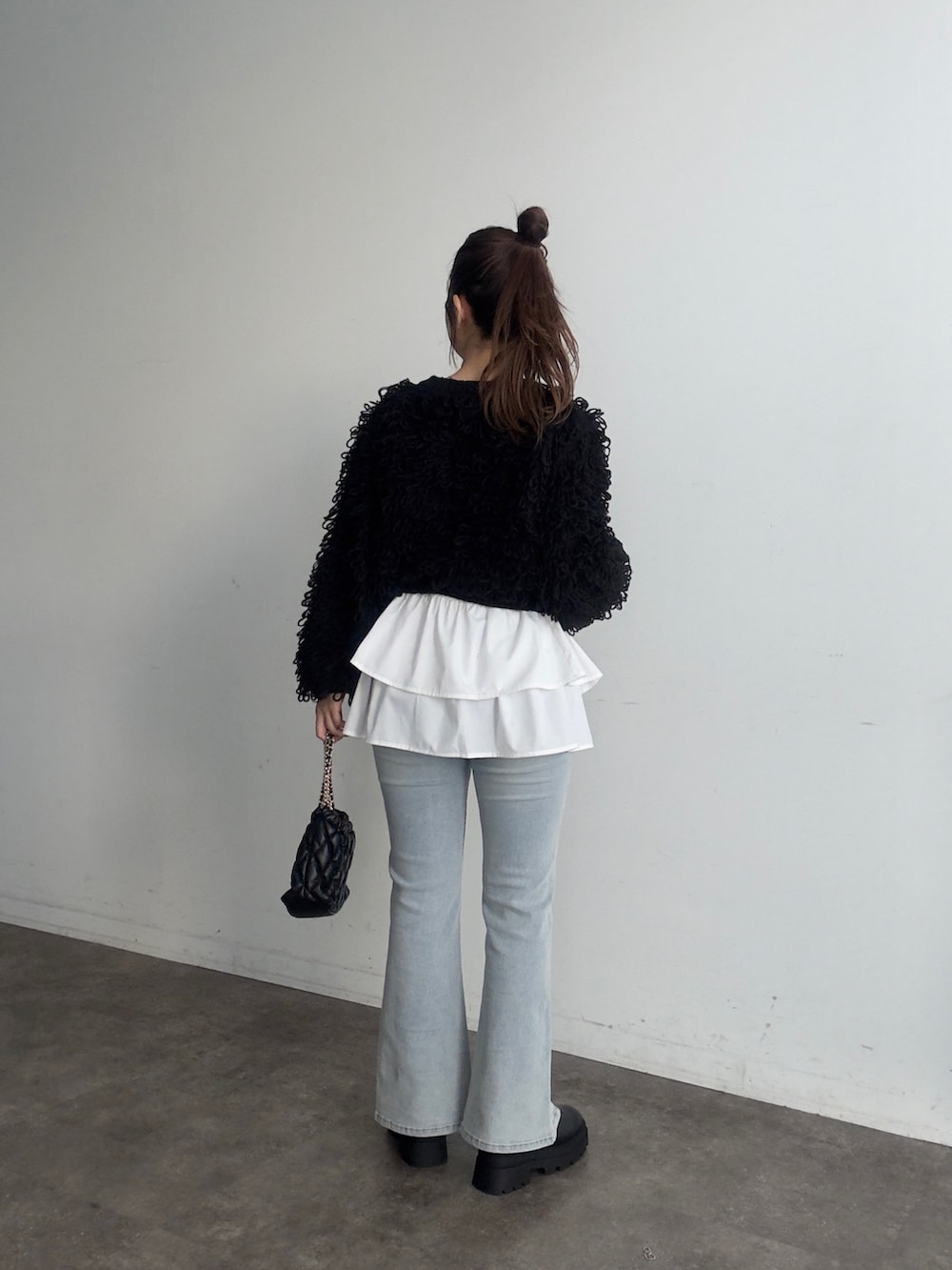 ブラック系のカーディガン/ボレロ、ホワイト系のスカート、ブルー系のデニムパンツを着用したレディースの夏コーディネートの3枚目の写真