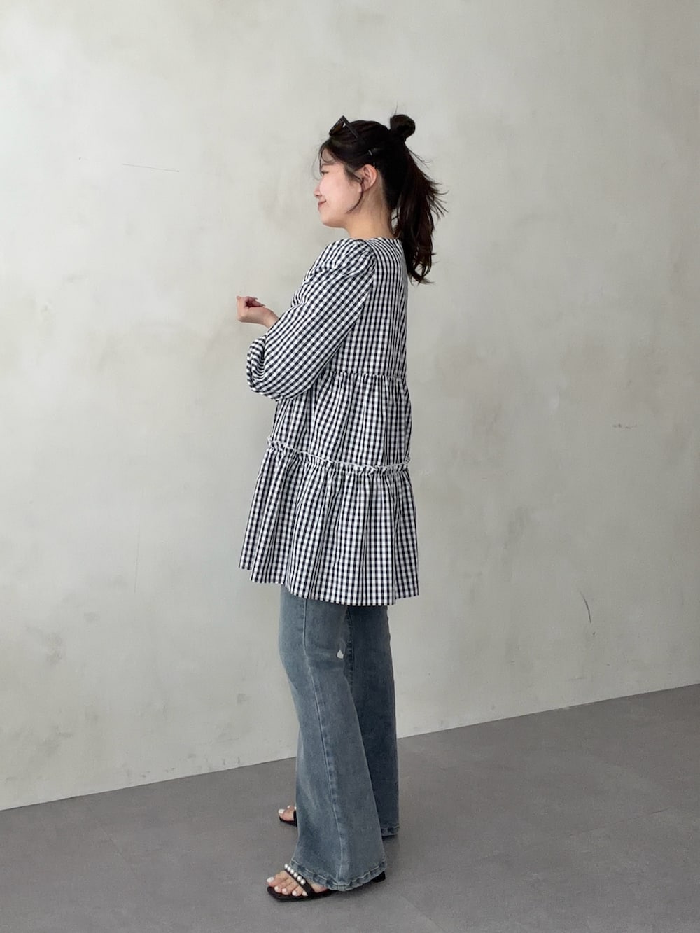 ブラック系のシャツ/ブラウス、ブルー系のデニムパンツ、ブラック系のサンダルを着用したレディースの春コーディネートの2枚目の写真