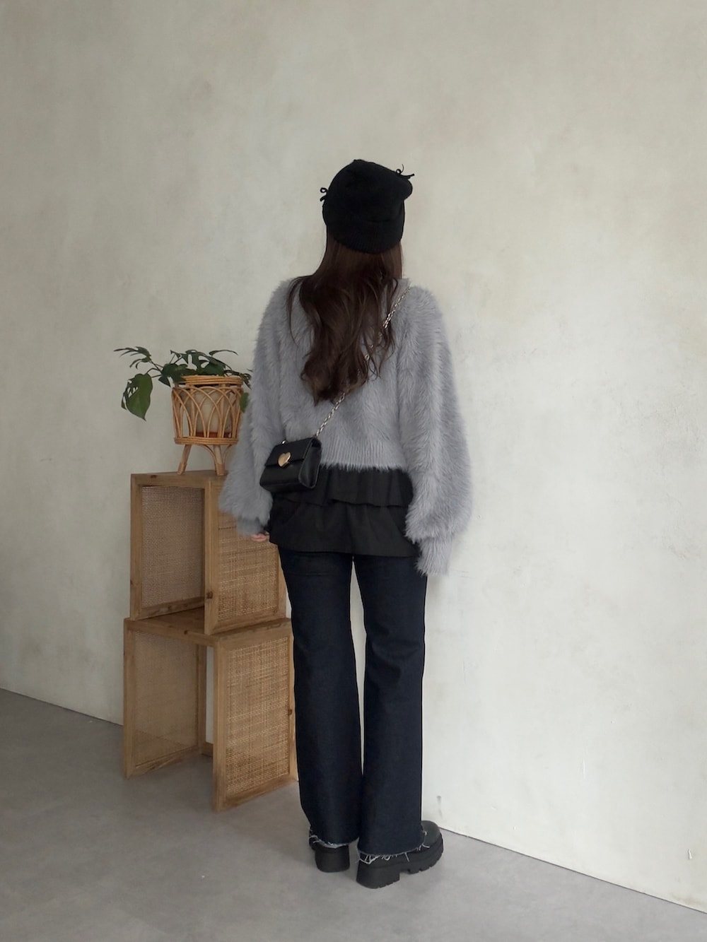 グレー系のカーディガン/ボレロ、ブラック系のスカート、ブルー系のデニムパンツを着用したレディースの秋コーディネートの3枚目の写真