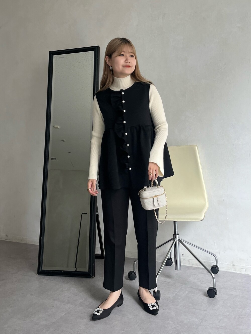 ブラック系のパンプス、ブラック系のその他パンツ、ホワイト系のショルダーバッグを着用したレディースの夏コーディネートの3枚目の写真
