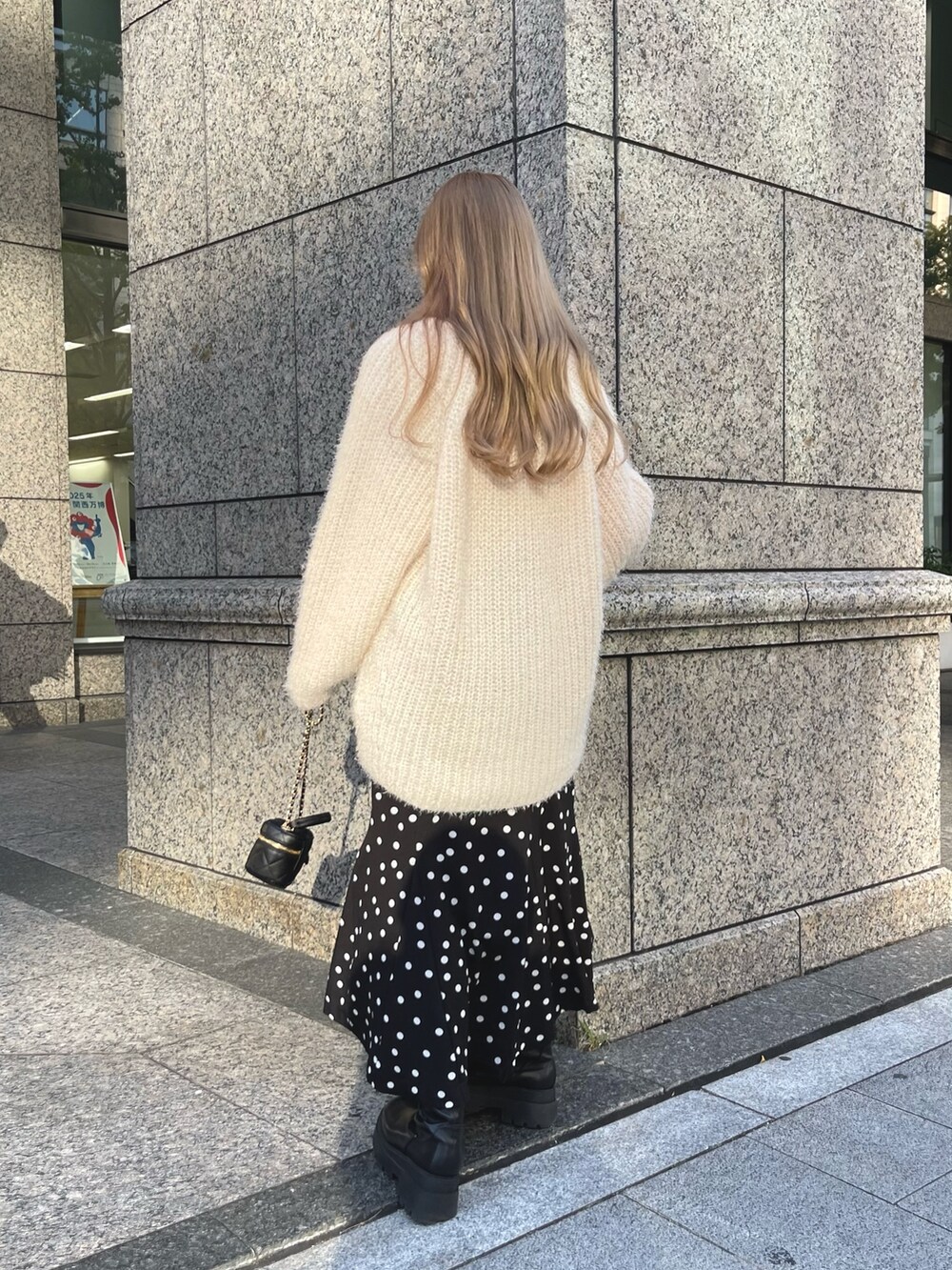 ベージュ系のニット/セーター、ブラック系のブーツ、ブラック系のショルダーバッグを着用したレディースの秋コーディネートの5枚目の写真