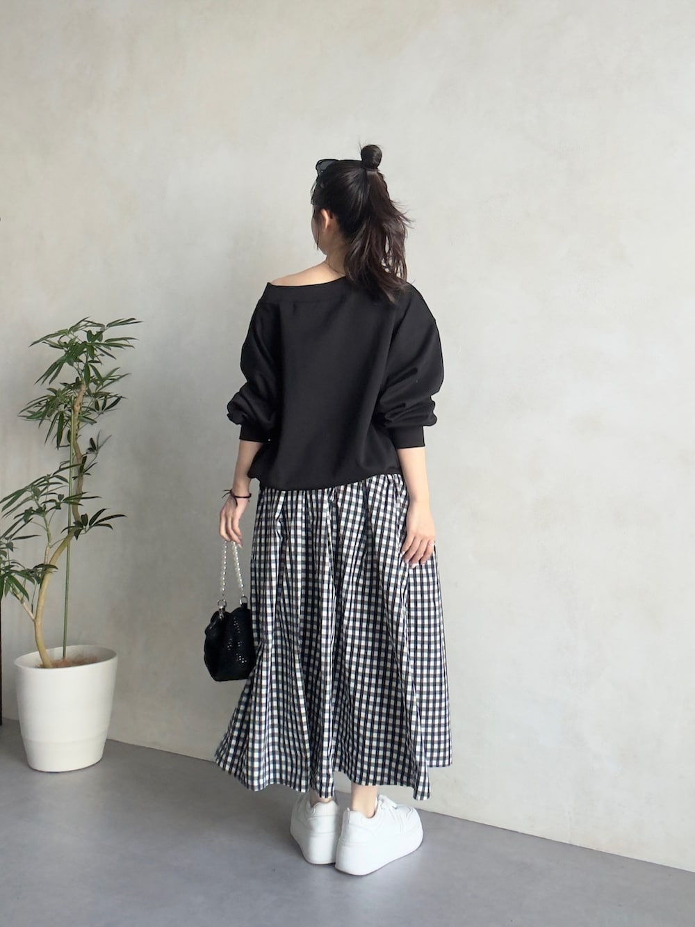 ブラック系のスカート、ホワイト系のスニーカー、ブラック系のTシャツ/カットソーを着用したレディースの春コーディネートの3枚目の写真