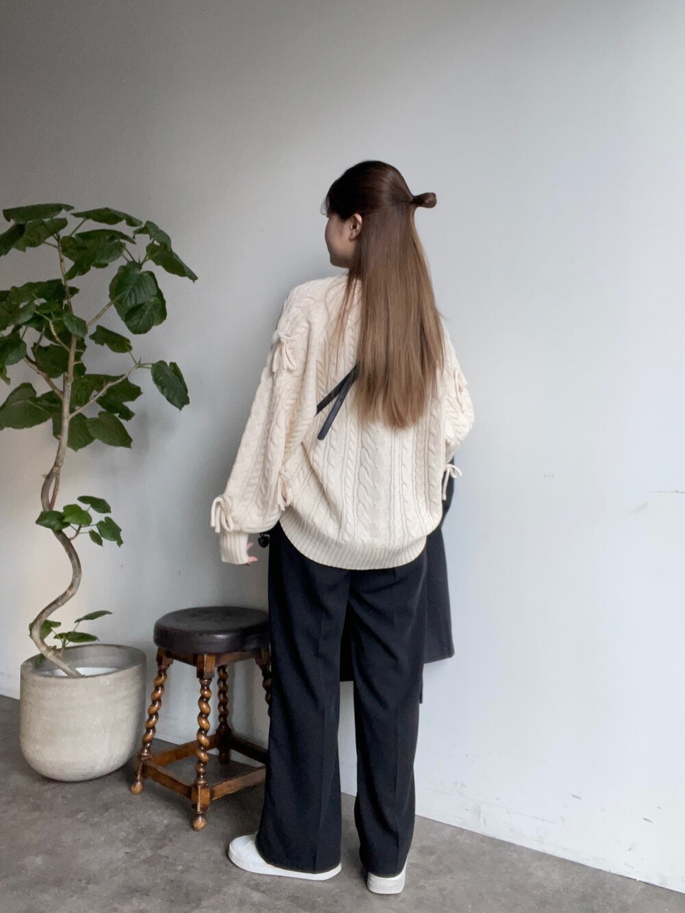 ホワイト系のニット/セーター、ブラック系のショルダーバッグ、ブラック系のスラックスを着用したレディースの冬コーディネートの2枚目の写真