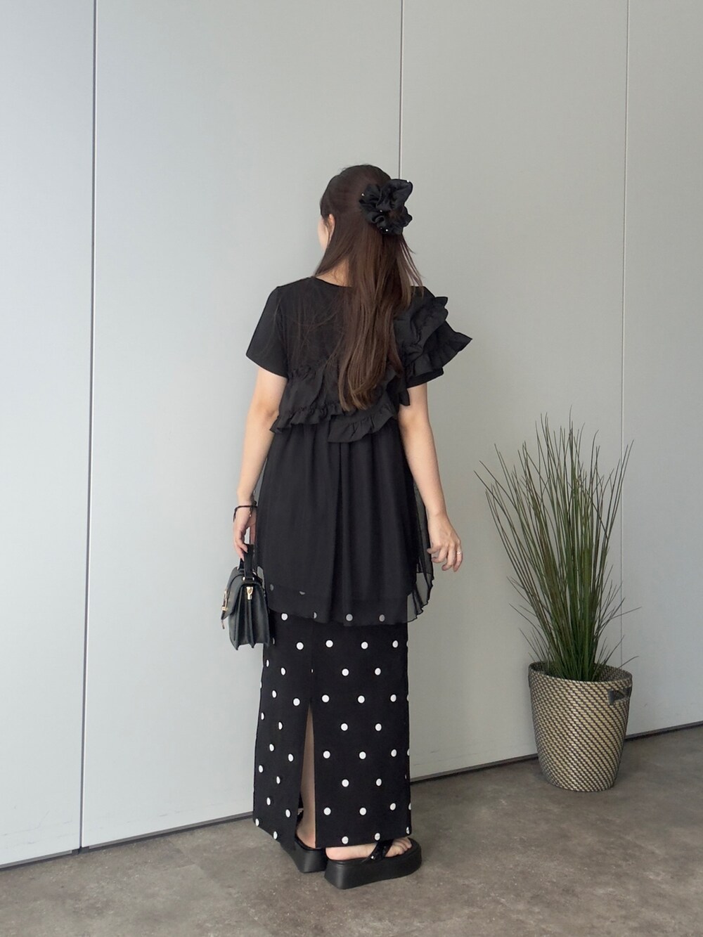 ブラック系のTシャツ/カットソー、ブラック系のスカート、ブラック系のサンダルを着用したレディースの夏コーディネートの3枚目の写真