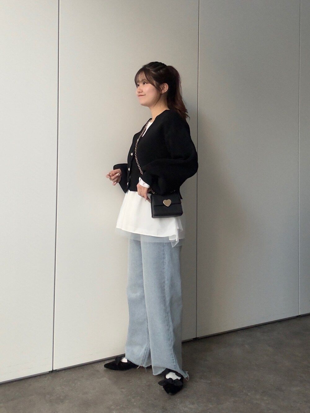 ブラック系のカーディガン/ボレロ、ホワイト系のTシャツ/カットソー、ブルー系のデニムパンツを着用したレディースの冬コーディネートの2枚目の写真