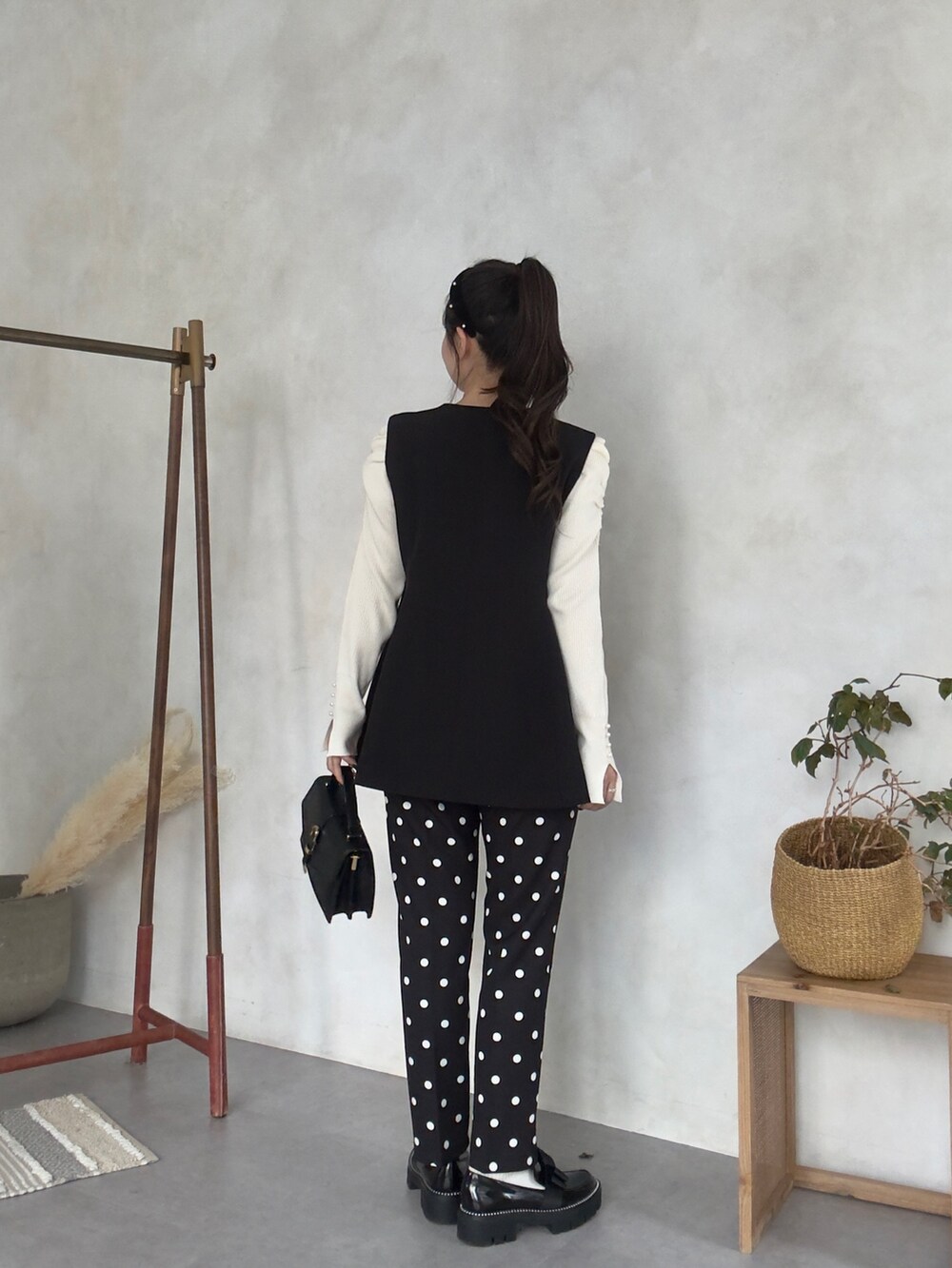 ホワイト系のニット/セーター、ブラック系のその他パンツ、ブラック系のローファーを着用したレディースの秋コーディネートの3枚目の写真