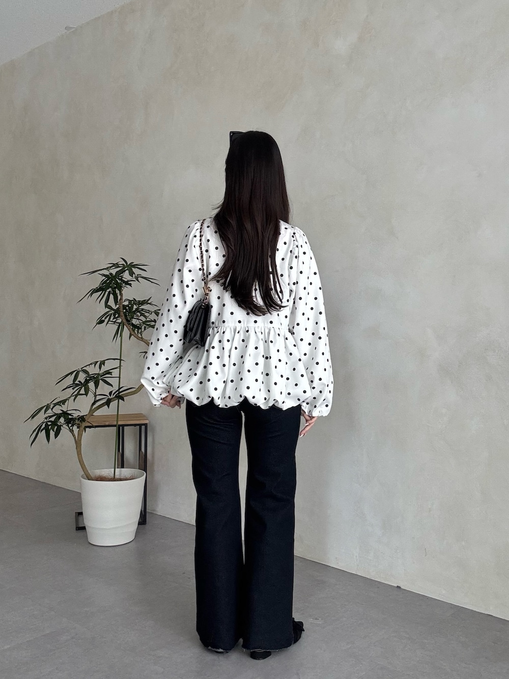 ブラック系のトートバッグ、ブルー系のデニムパンツ、ブラック系のパンプスを着用したレディースの春コーディネートの3枚目の写真