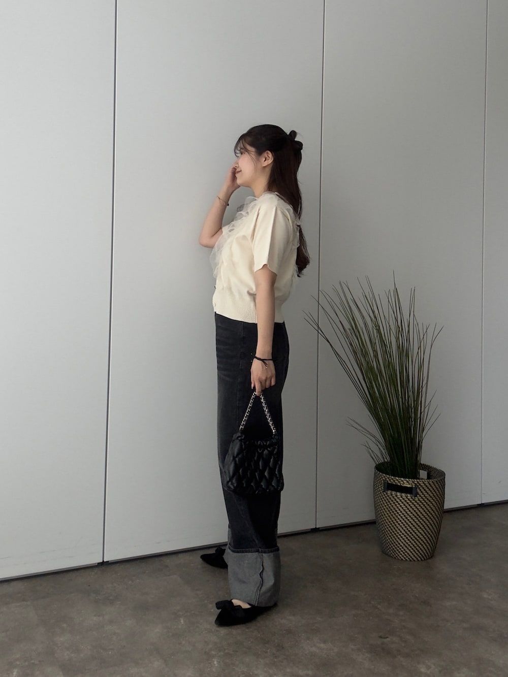 ホワイト系のカーディガン/ボレロ、ブラック系のパンプス、ブラック系のデニムパンツを着用したレディースの春コーディネートの2枚目の写真