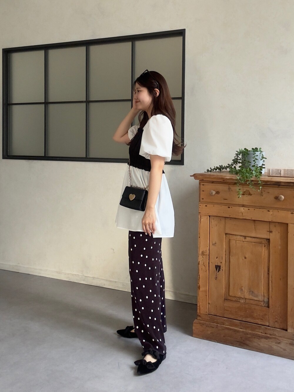 ホワイト系のシャツ/ブラウス、ブラック系のパンプス、ブラック系のその他パンツを着用したレディースの春コーディネートの2枚目の写真