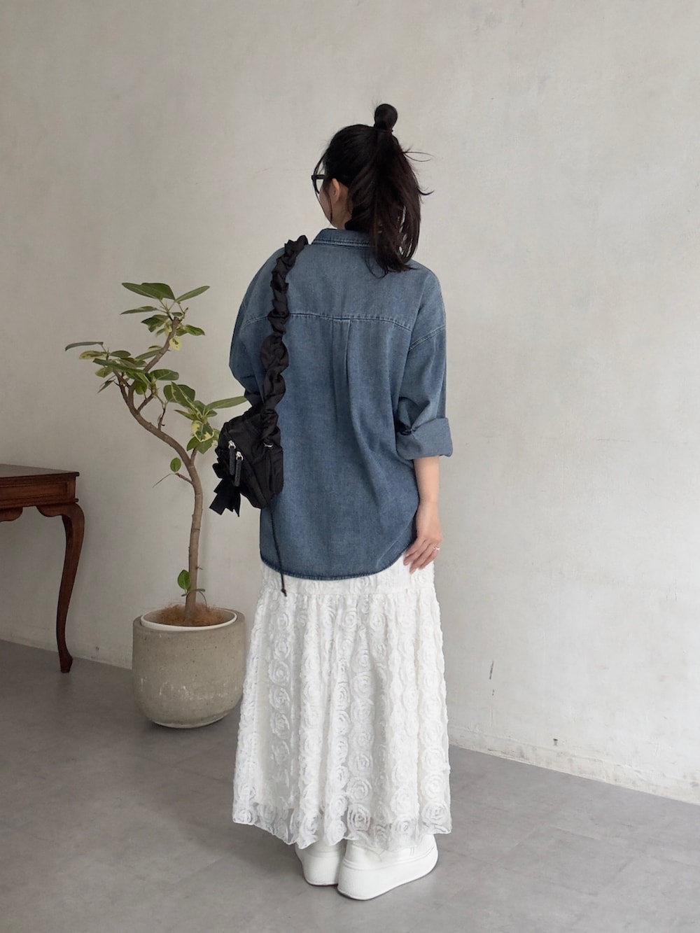 ホワイト系のスニーカー、ブルー系のシャツ/ブラウス、ブラック系のショルダーバッグを着用したレディースの春コーディネートの3枚目の写真