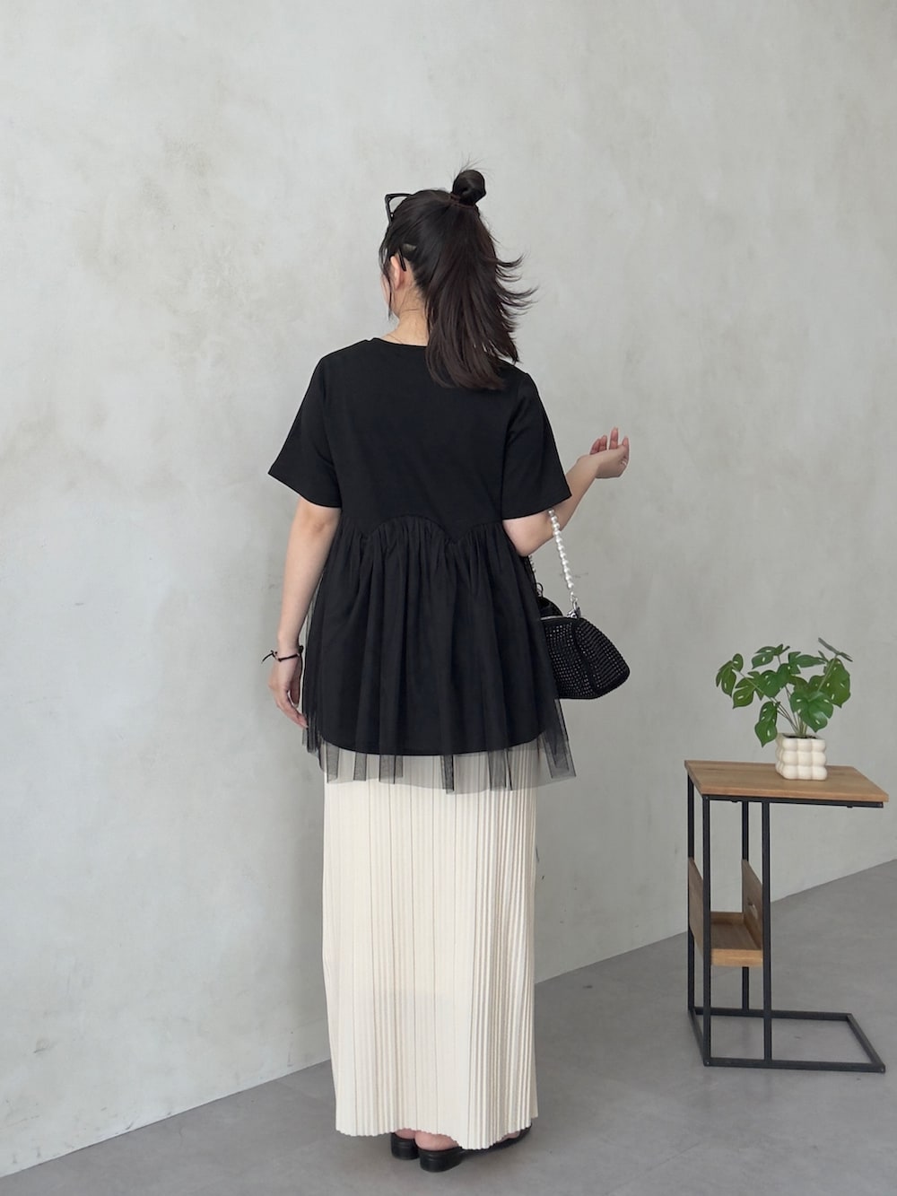 ブラック系のサンダル、ブラック系のTシャツ/カットソー、ホワイト系のスカートを着用したレディースの夏コーディネートの3枚目の写真
