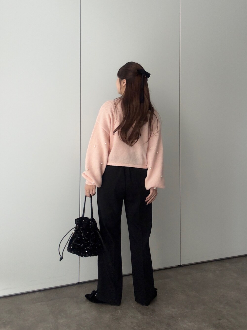 ピンク系のカーディガン/ボレロ、ホワイト系のTシャツ/カットソー、ブラック系のショルダーバッグを着用したレディースの冬コーディネートの3枚目の写真