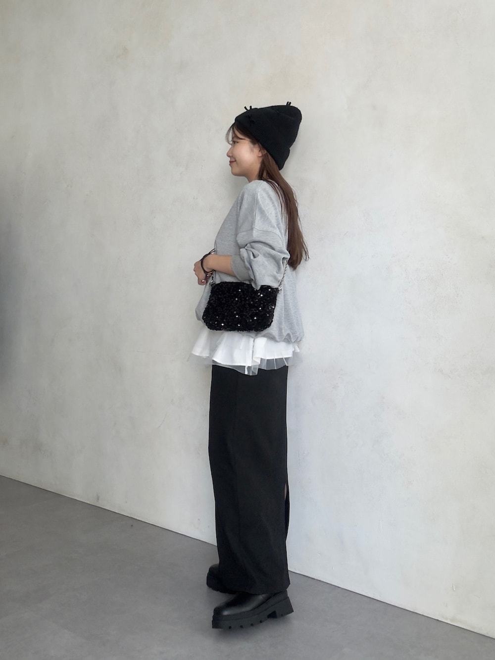 ホワイト系のキャミソール、ブラック系のスカート、ブラック系のブーツを着用したレディースの夏コーディネートの2枚目の写真