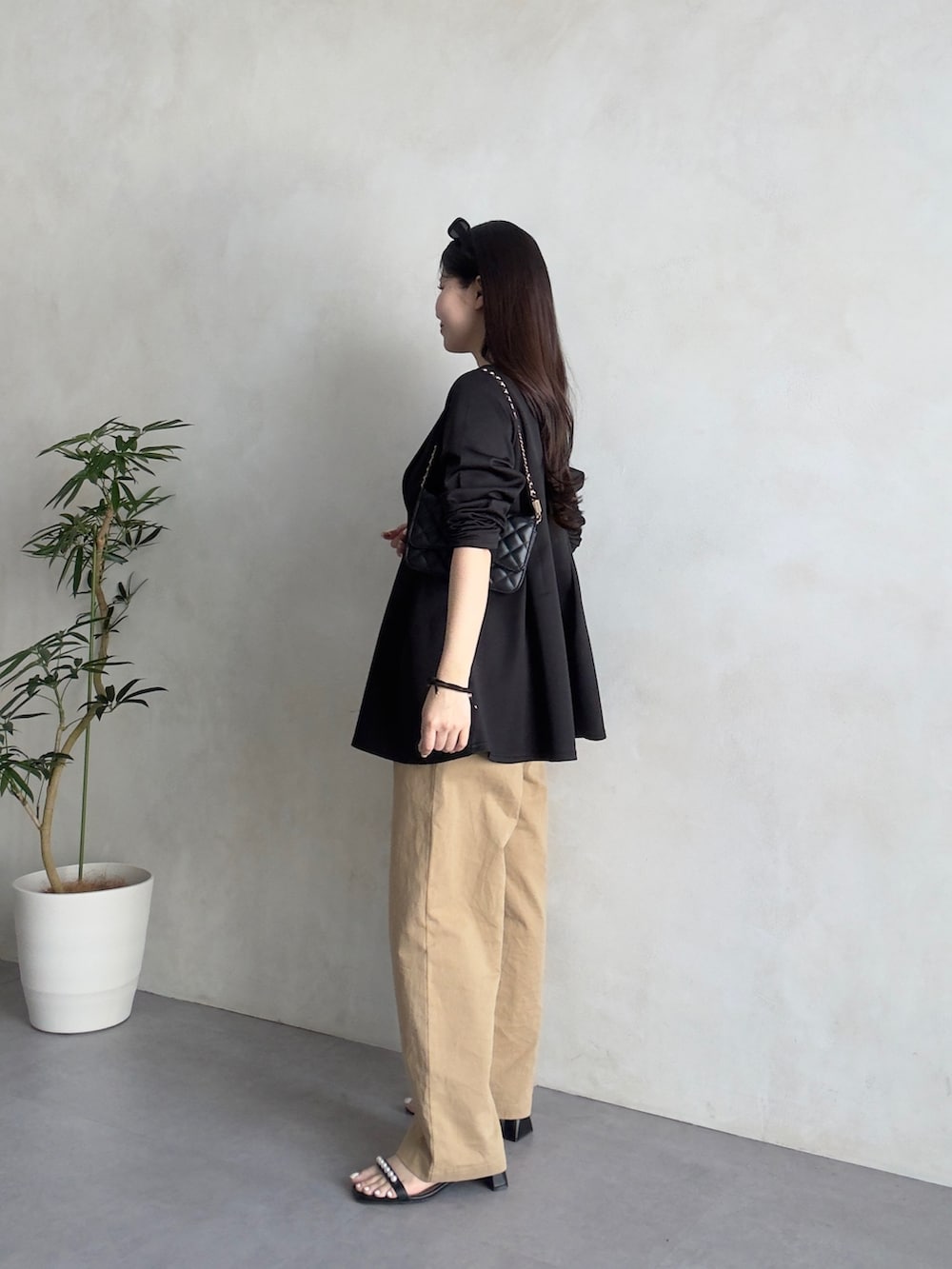 ブラック系のトートバッグ、ベージュ系のチノパンツ、ブラック系のサンダルを着用したレディースの春コーディネートの2枚目の写真