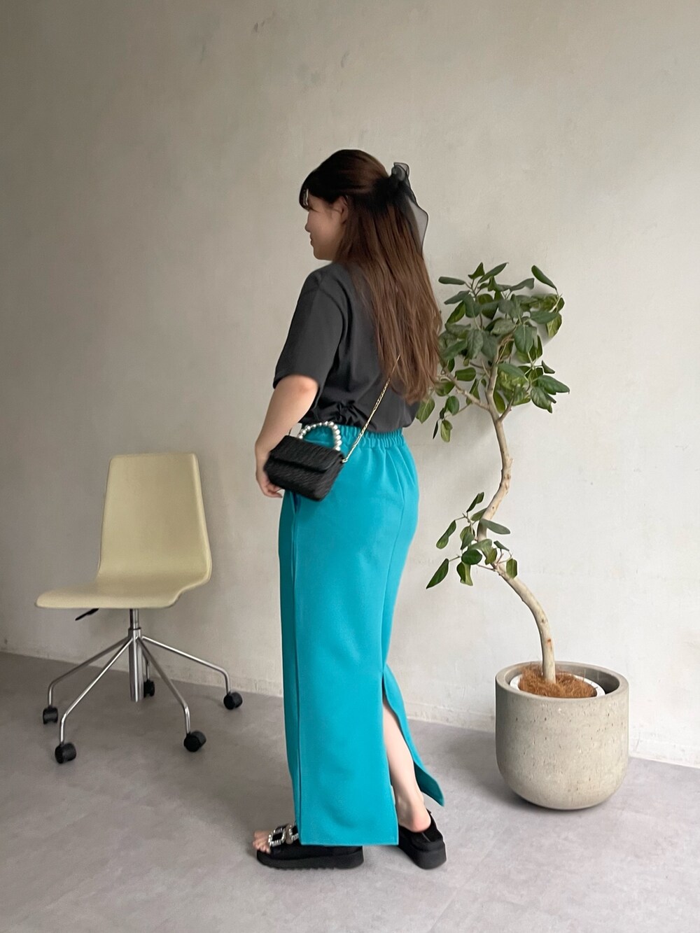 ブラック系のショルダーバッグ、ブラック系のサンダル、グレー系のTシャツ/カットソーを着用したレディースの春コーディネートの2枚目の写真