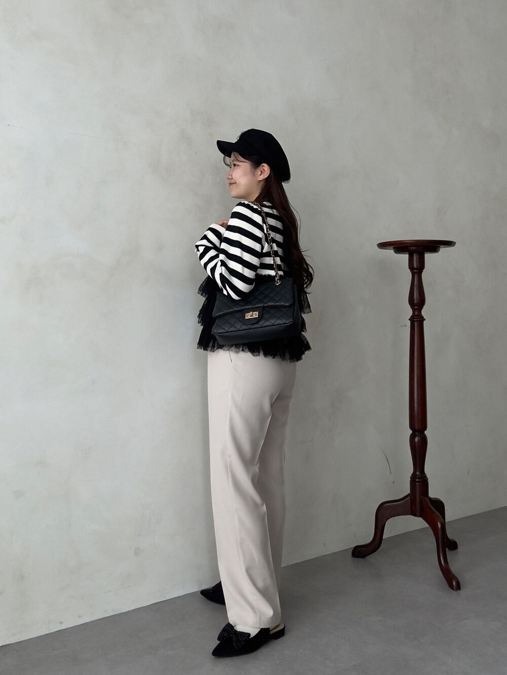 ブラック系のショルダーバッグ、ホワイト系のその他パンツ、ブラック系のニット/セーターを着用したレディースの秋コーディネートの2枚目の写真