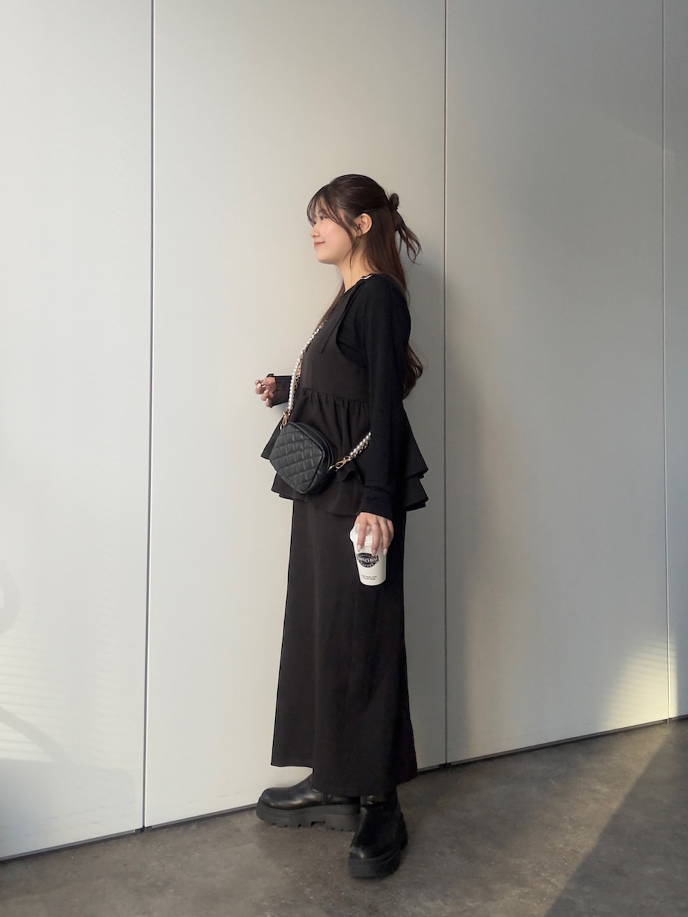 ブラック系のTシャツ/カットソー、ブラック系のショルダーバッグ、ブラック系のワンピースを着用したレディースの冬コーディネートの2枚目の写真