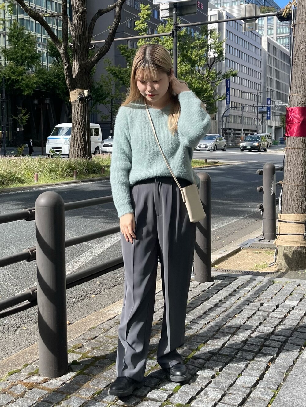 グリーン系のニット/セーター、グレー系のその他パンツを着用したレディースの秋コーディネートの4枚目の写真