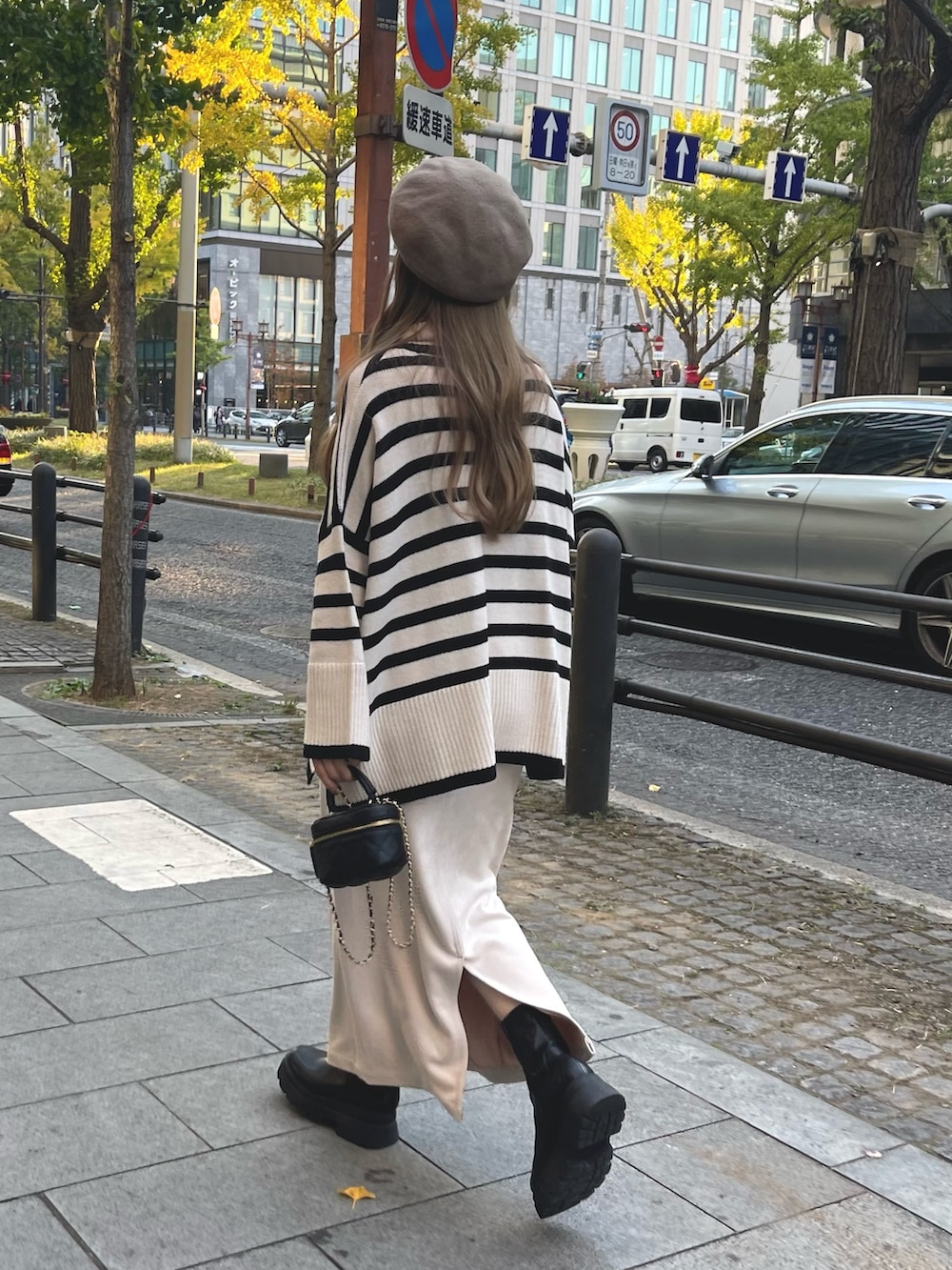 ホワイト系のスカート、ブラック系のブーツ、ブラック系のショルダーバッグを着用したレディースの秋コーディネートの4枚目の写真