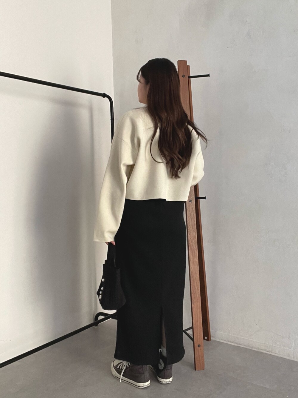 ホワイト系のカーディガン/ボレロ、ブラック系のトートバッグ、ブラック系のスカートを着用したレディースの春コーディネートの3枚目の写真