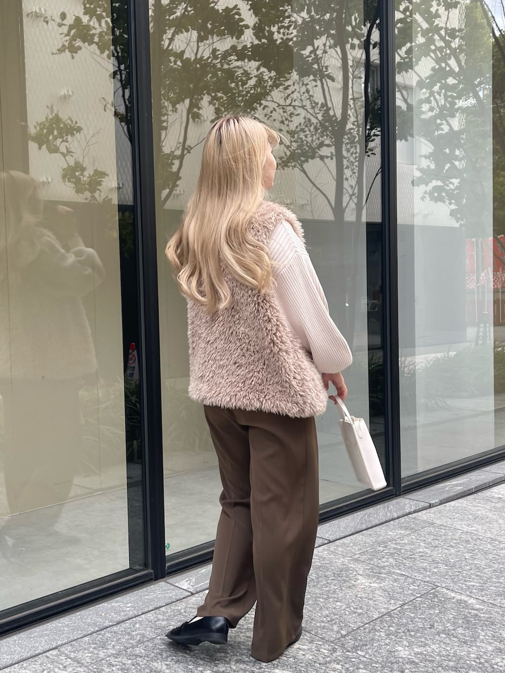 ホワイト系のニット/セーター、ベージュ系のベスト、ブラウン系のその他パンツを着用したレディースの秋コーディネートの4枚目の写真