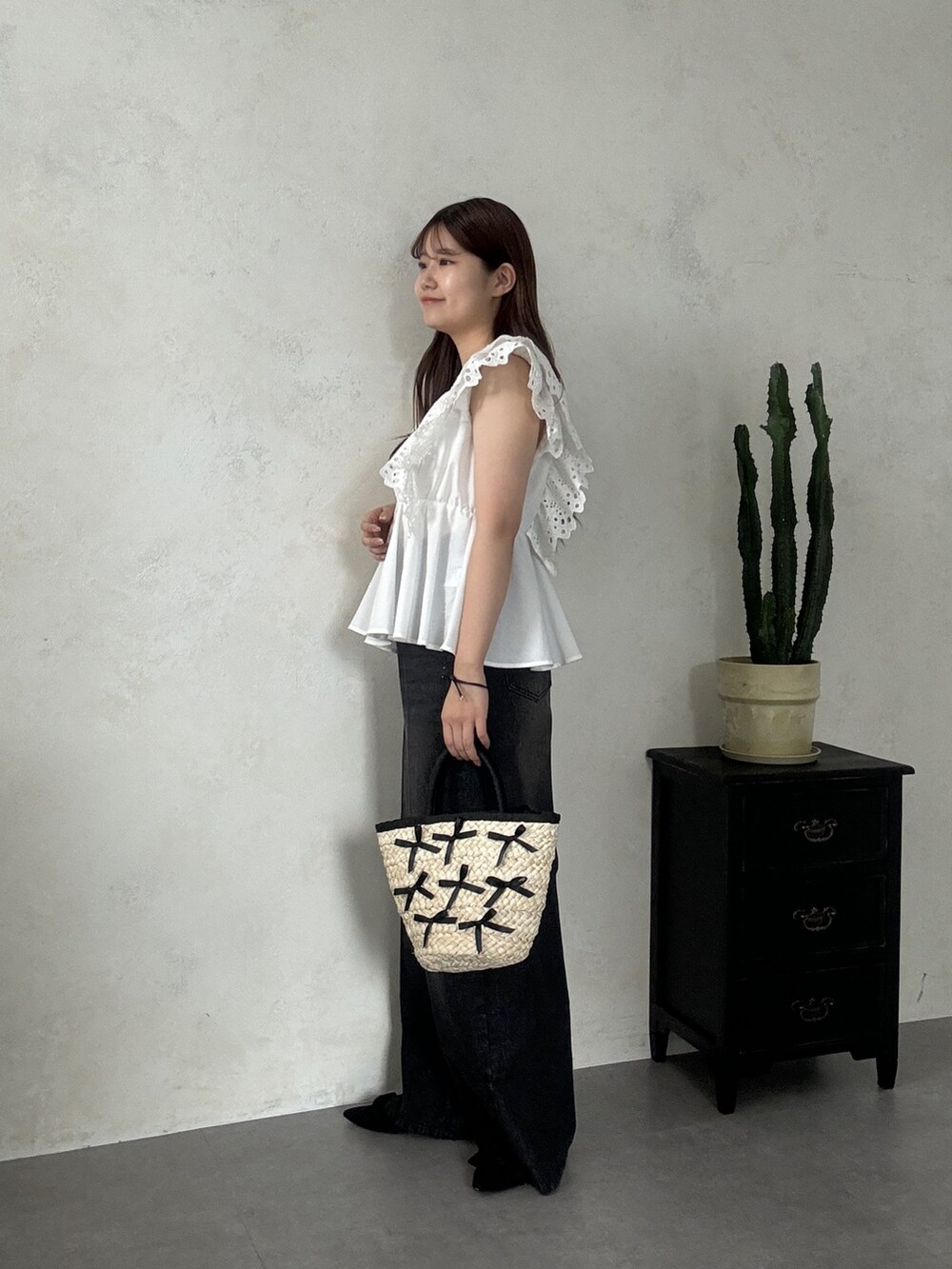 ホワイト系のシャツ/ブラウス、ブラック系のデニムパンツ、ブラック系のかごバッグを着用したレディースの夏コーディネートの2枚目の写真