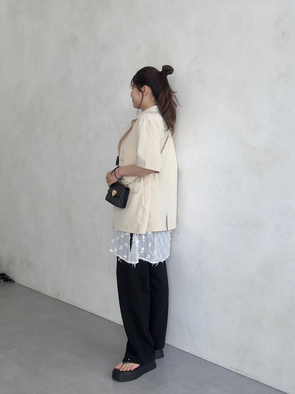 ベージュ系のテーラードジャケット、ブラック系のその他パンツ、ブラック系のサンダルを着用したレディースの夏コーディネートの2枚目の写真