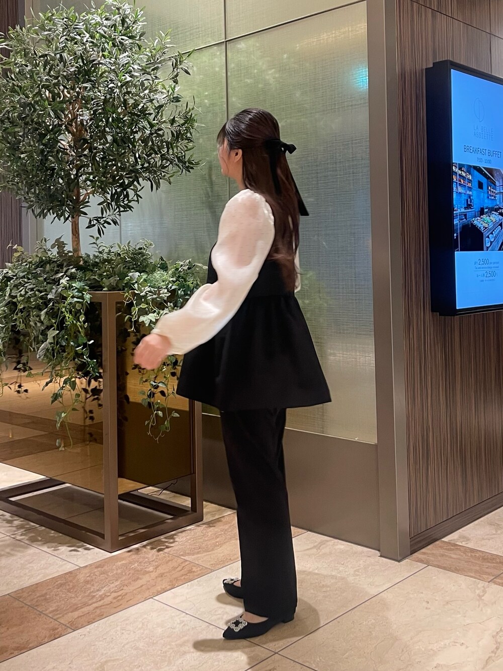 ホワイト系のシャツ/ブラウス、ブラック系のスラックス、ブラック系のパンプスを着用したレディースの冬コーディネートの3枚目の写真