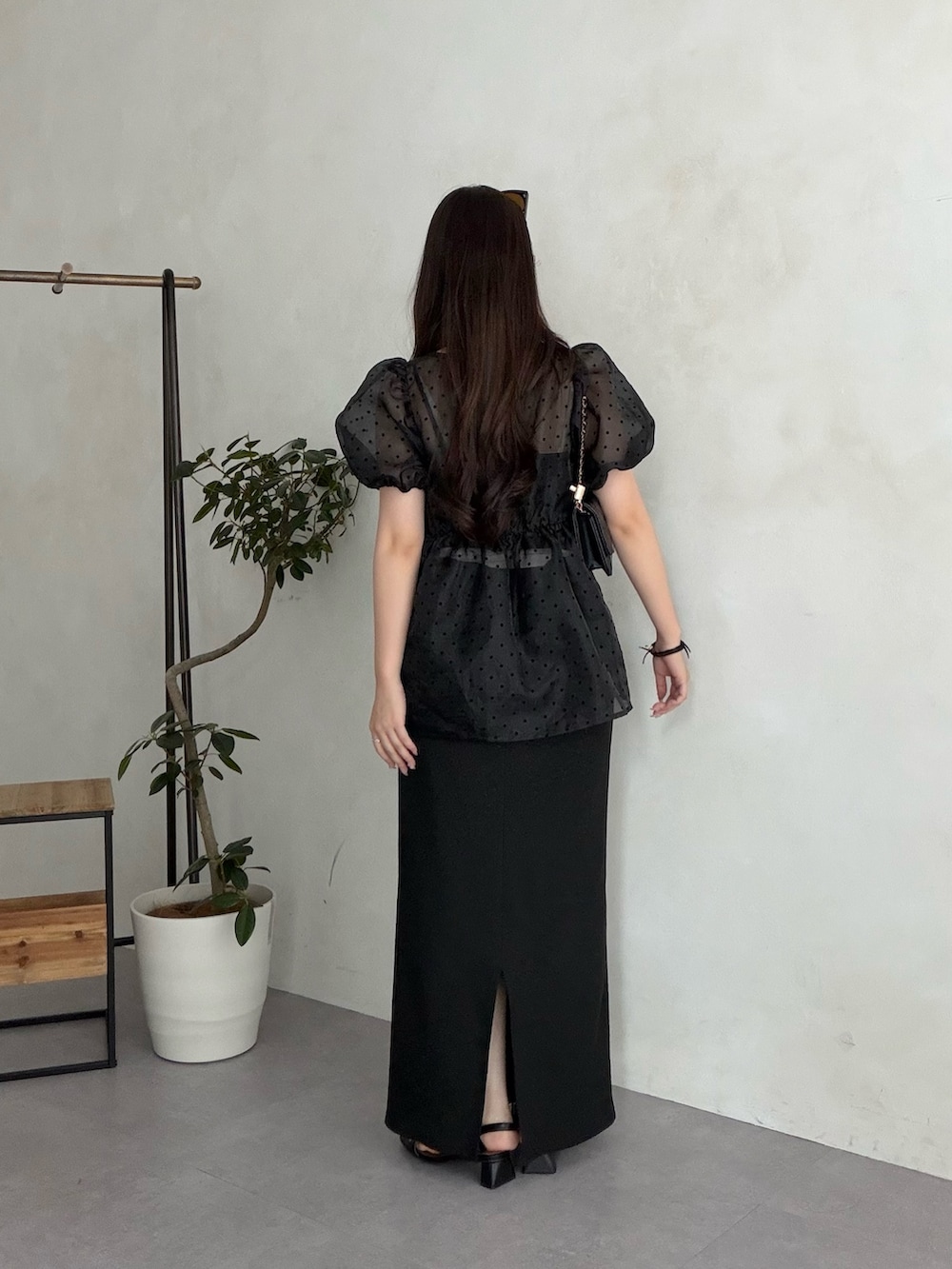 ブラック系のトートバッグ、ブラック系のスカート、ブラック系のサンダルを着用したレディースの夏コーディネートの3枚目の写真