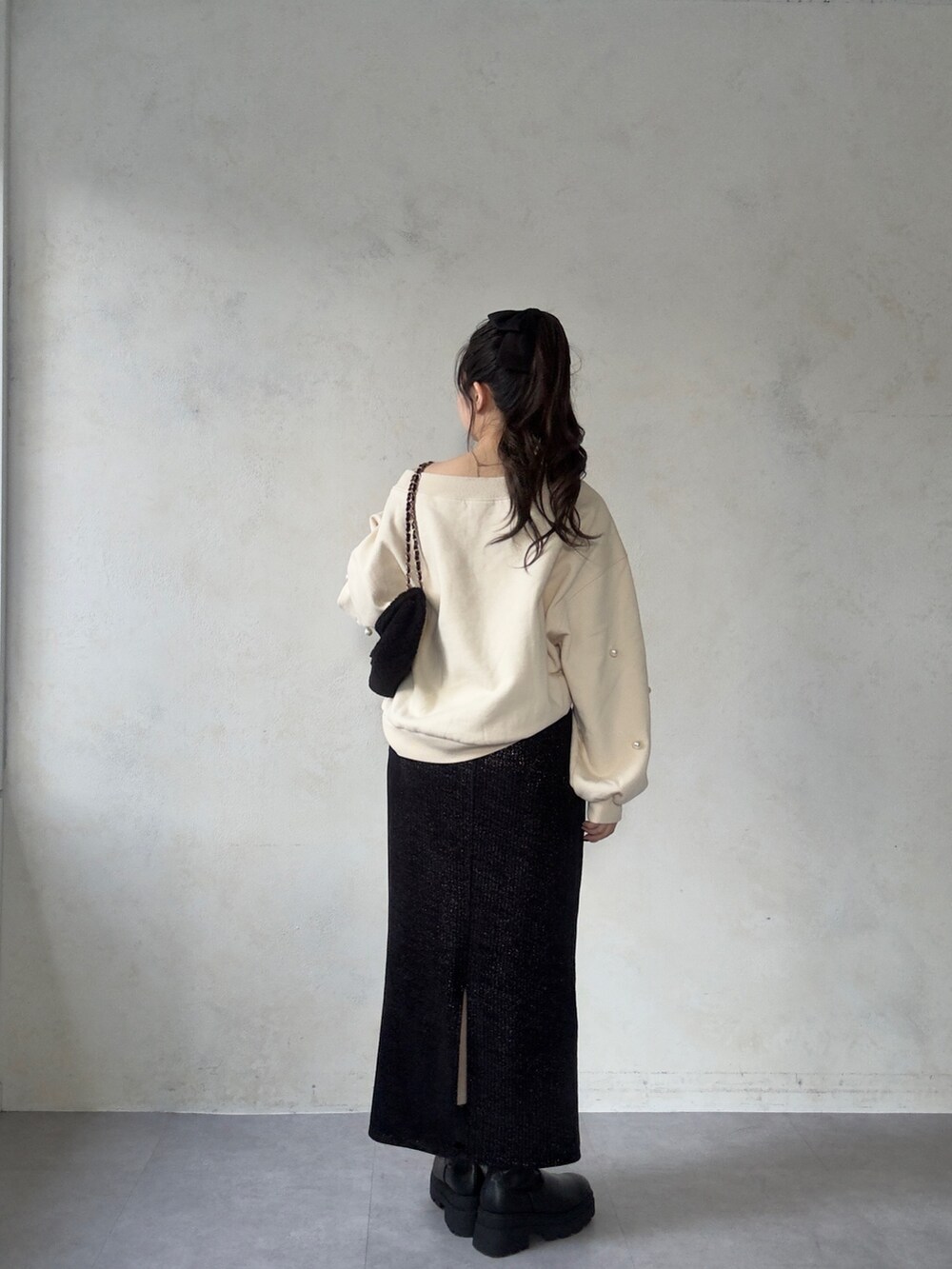 ホワイト系のTシャツ/カットソー、ブラック系のブーツ、ブラック系のスカートを着用したレディースの秋コーディネートの3枚目の写真