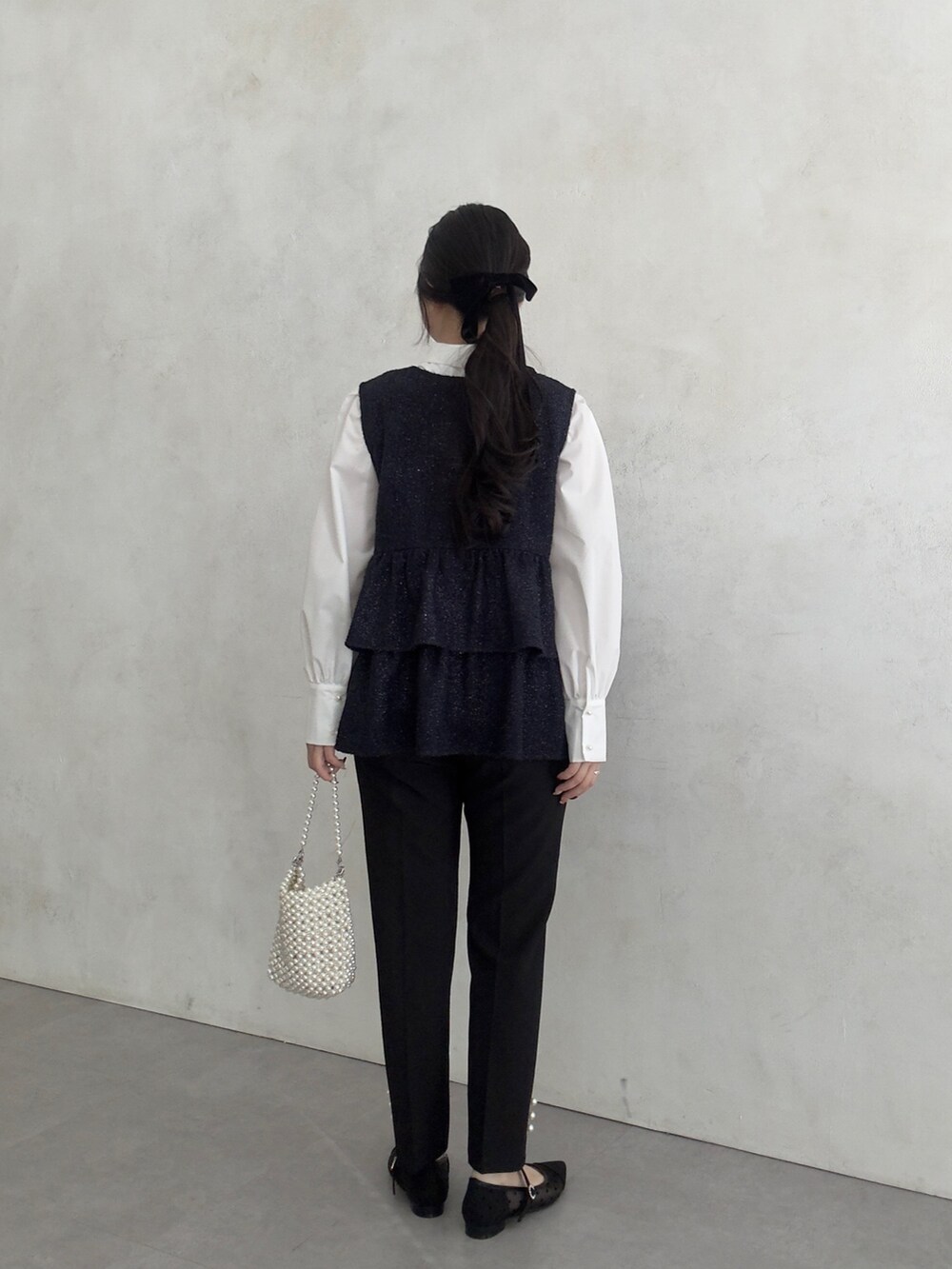 ホワイト系のシャツ/ブラウス、ブラック系のベスト、ブラック系のその他パンツを着用したレディースの冬コーディネートの3枚目の写真