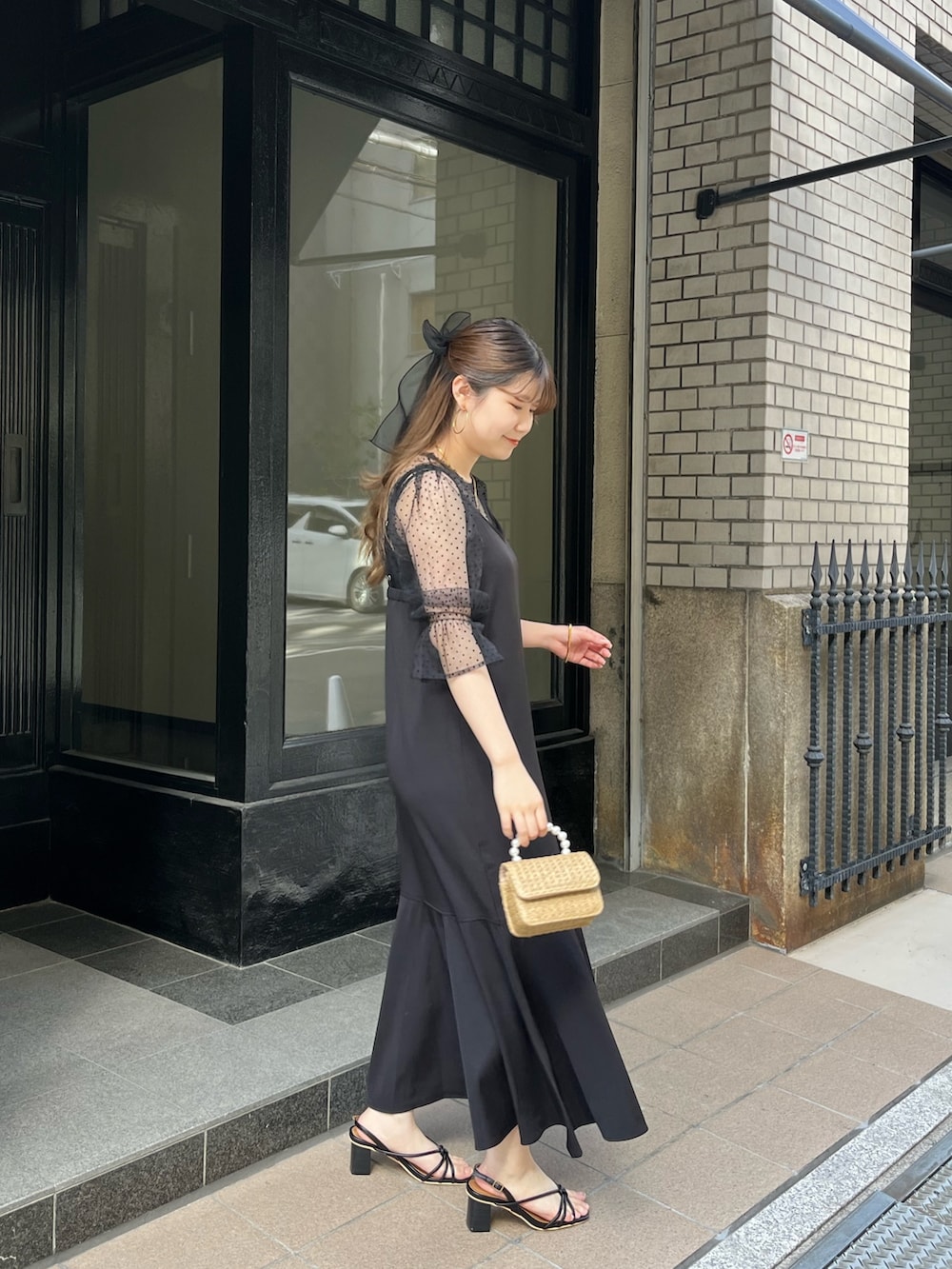 ブラック系のドレス、ブラック系のヘアゴム、ゴールド系のネックレスを着用したレディースの春コーディネートの2枚目の写真