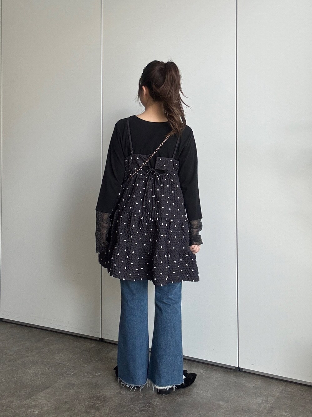 ブラック系のTシャツ/カットソー、ブラック系のキャミソール、ブルー系のデニムパンツを着用したレディースの春コーディネートの3枚目の写真