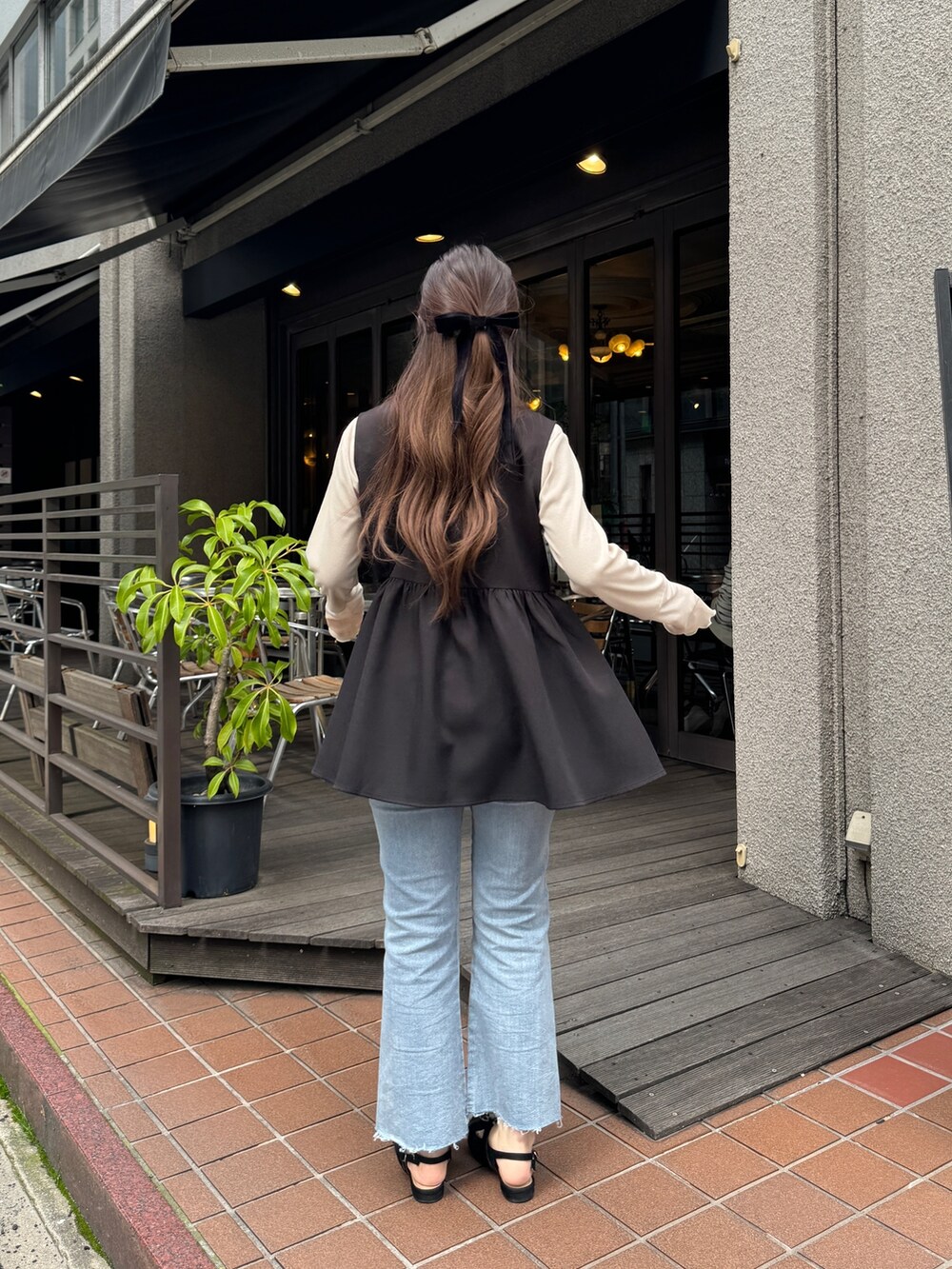 ホワイト系のTシャツ/カットソー、ブラック系のショルダーバッグ、ブルー系のデニムパンツを着用したレディースの春コーディネートの2枚目の写真