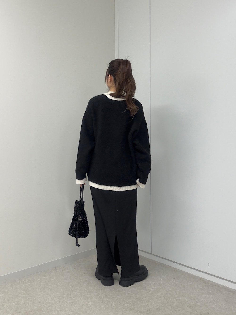 ホワイト系のニット/セーター、ホワイト系のカーディガン/ボレロ、ブラック系のショルダーバッグを着用したレディースの冬コーディネートの3枚目の写真