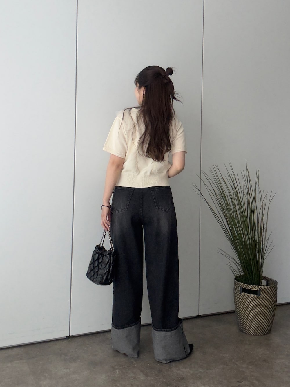 ホワイト系のカーディガン/ボレロ、ブラック系のパンプス、ブラック系のデニムパンツを着用したレディースの春コーディネートの3枚目の写真