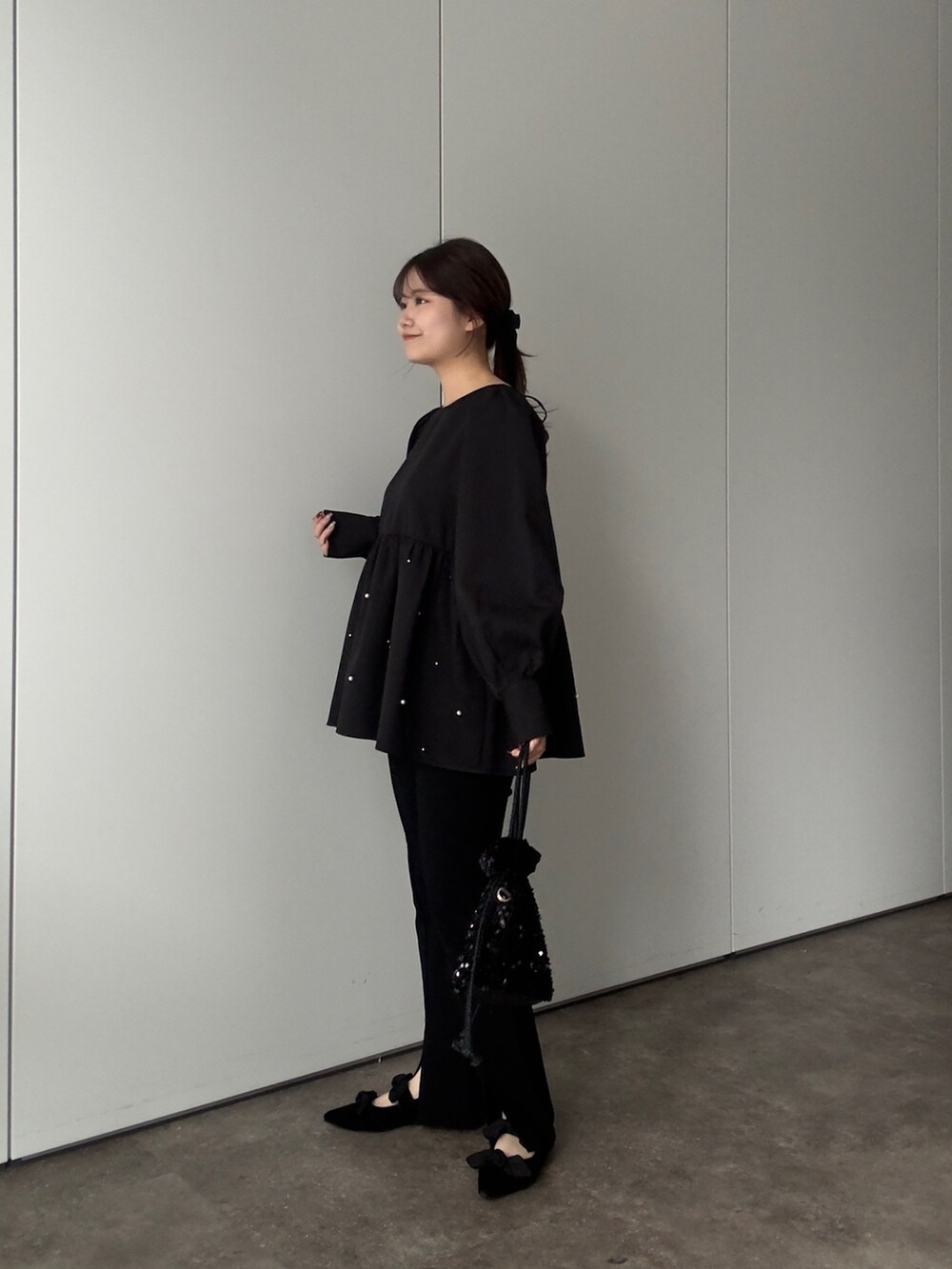 ブラック系のシャツ/ブラウス、ブラック系のショルダーバッグ、ブラック系のその他パンツを着用したレディースの春コーディネートの2枚目の写真