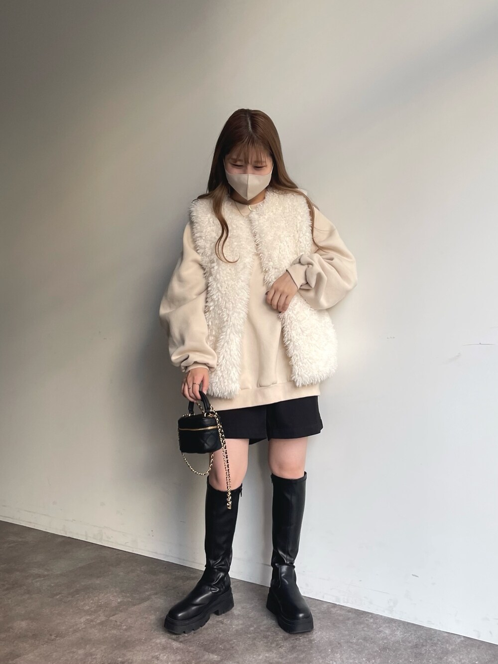 ホワイト系のスウェット、ホワイト系のベスト、ブラック系のその他パンツを着用したレディースの秋コーディネートの4枚目の写真