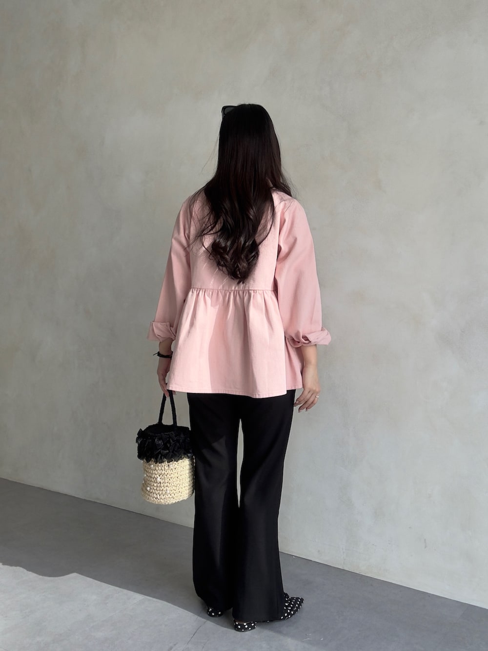 ホワイト系のパンツドレス、ピンク系のブルゾンを着用したレディースの冬コーディネートの3枚目の写真