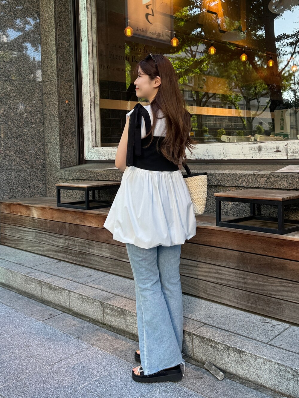 ホワイト系のシャツ/ブラウス、ブラック系のかごバッグ、ブルー系のデニムパンツを着用したレディースの夏コーディネートの2枚目の写真