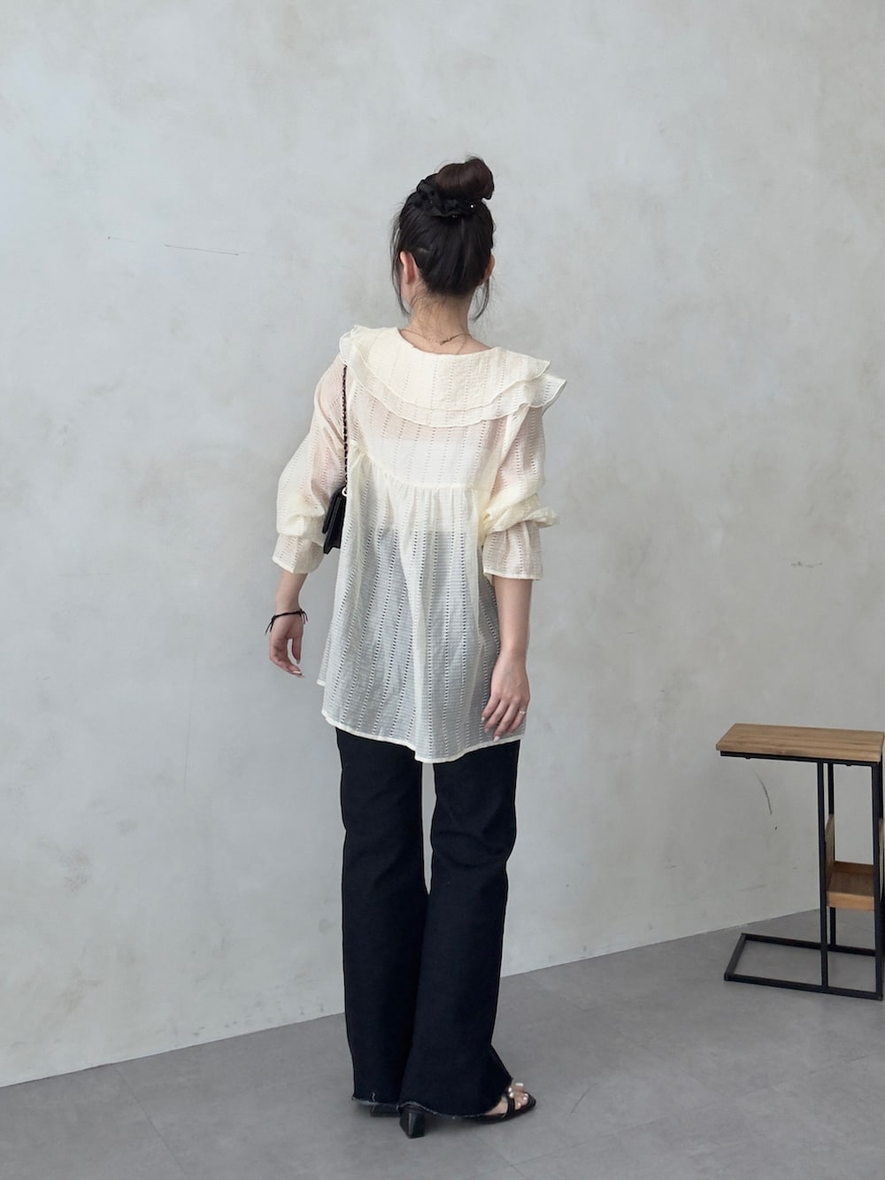 ブラック系のトートバッグ、ブルー系のデニムパンツ、ブラック系のサンダルを着用したレディースの春コーディネートの3枚目の写真