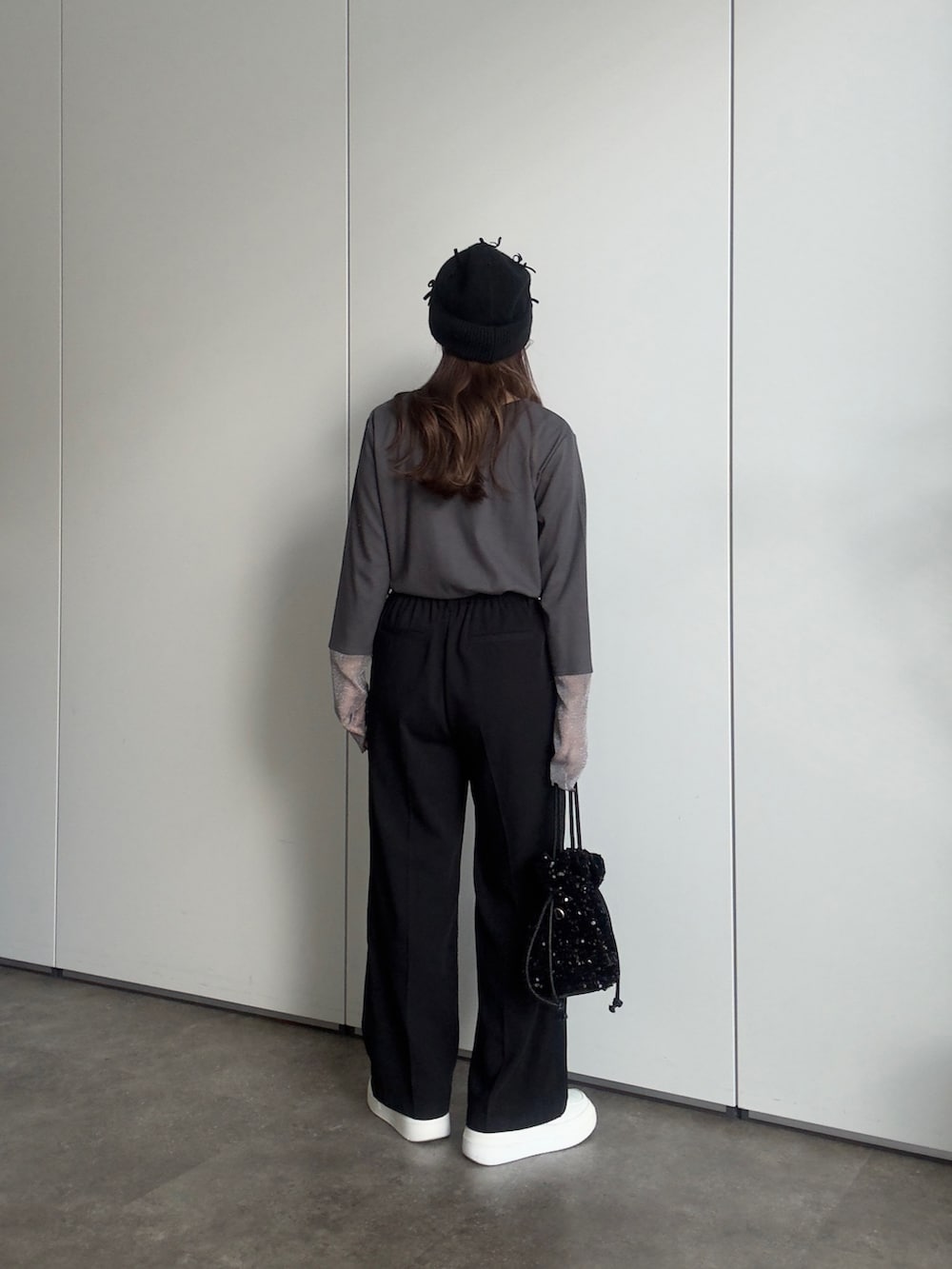 グレー系のTシャツ/カットソー、ブラック系のスラックス、ブラック系のショルダーバッグを着用したレディースの春コーディネートの3枚目の写真