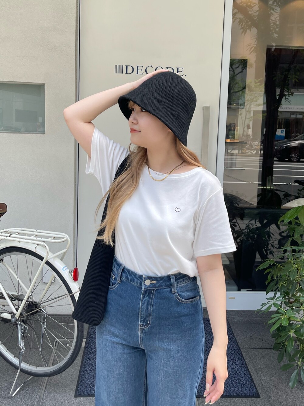 ピンク系のTシャツ/カットソー、ブルー系のデニムパンツ、ブラック系のトートバッグを着用したレディースの夏コーディネートの3枚目の写真